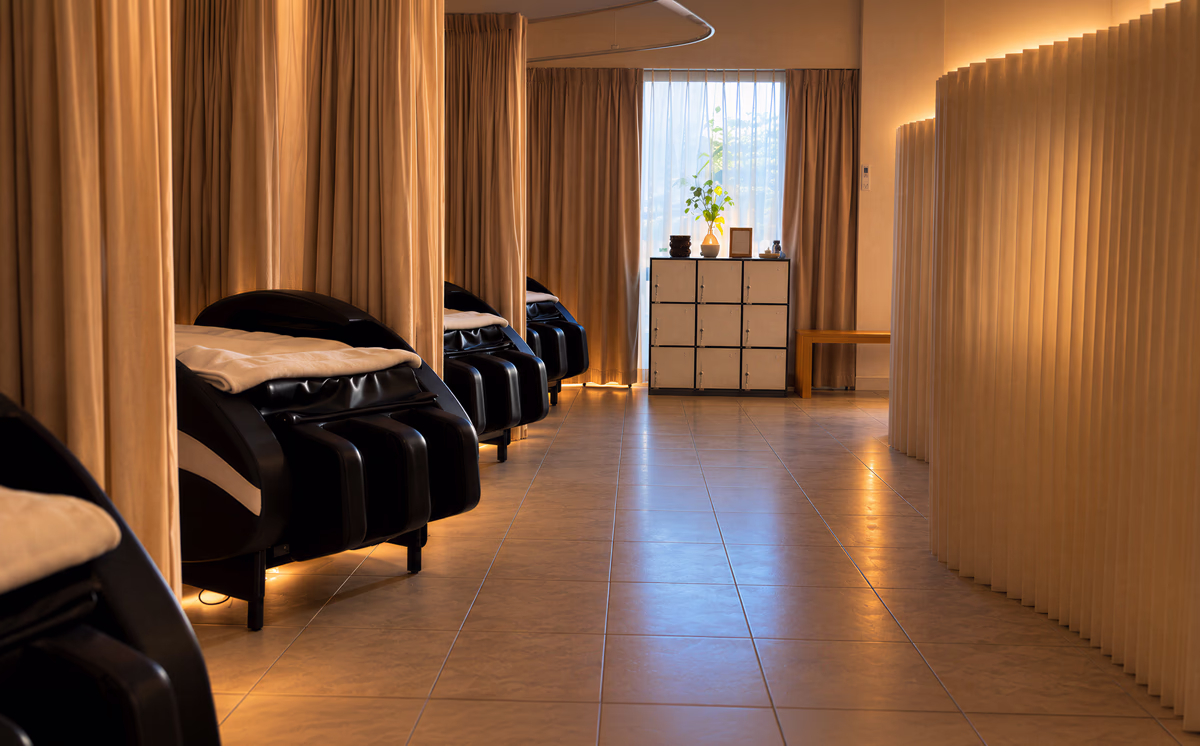 Reclining head spa chairs along a curtained treatment room.